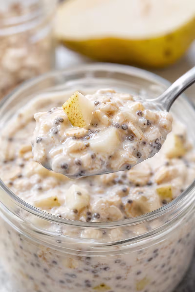 Löffel mit Birnen Overnight Oats Löffel mit cremigen Birnen Overnight Oats und Chiasamen in Nahaufnahme