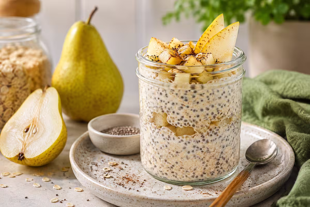 Cremige Overnight Oats Birne mit Chiasamen im Glas, dekoriert mit frischen Birnenstücken und Zimt auf hellem Frühstückstisch